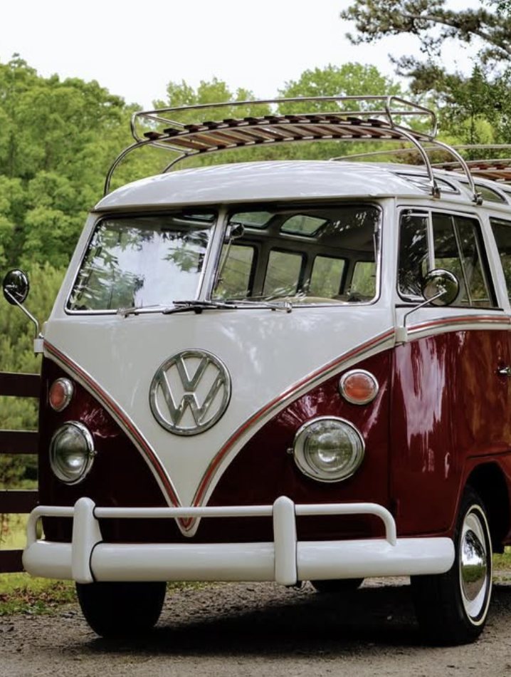 Restored red and white split-window Volkswagen Bus with roof rack
