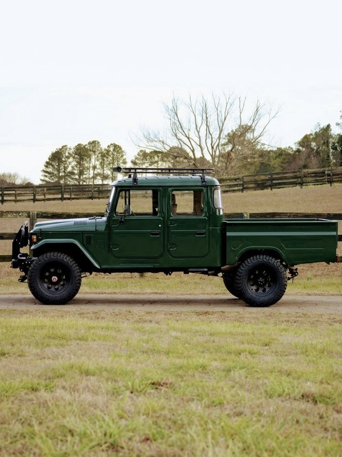 1997 Toyota Bandeirante four-door crew cab in deep forest green, full side profile with roof rack and steel bed