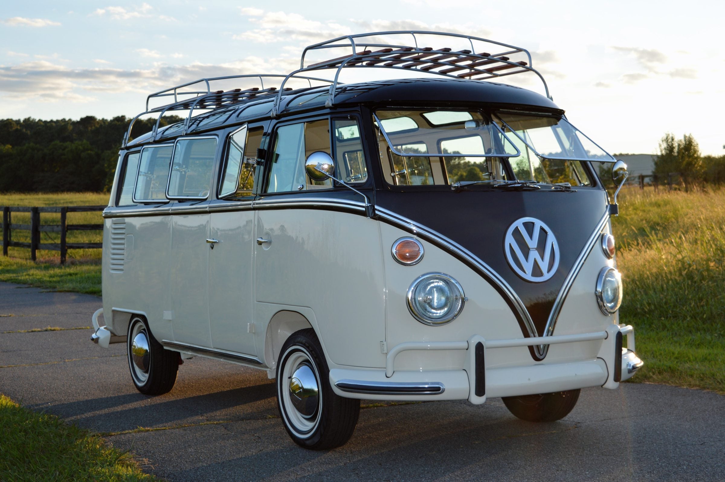 Restored black and white 23-window Volkswagen Bus at sunset